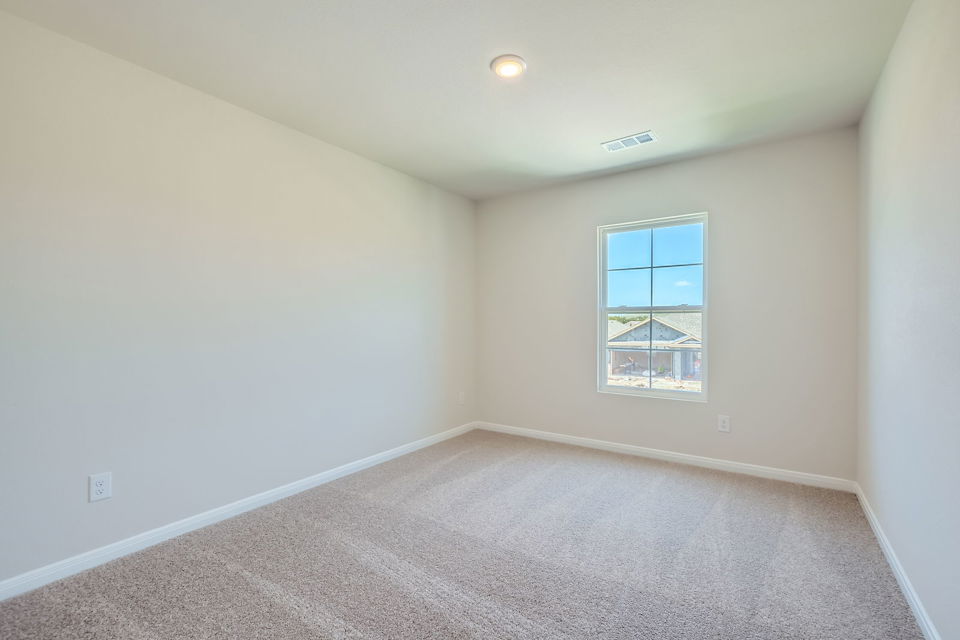 A room with a window and carpet.