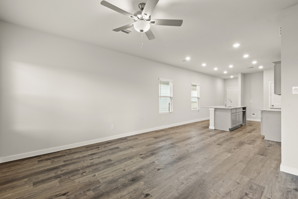 A room with a wood floor and a ceiling fan.