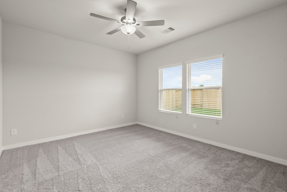 A room with a ceiling fan and a window.