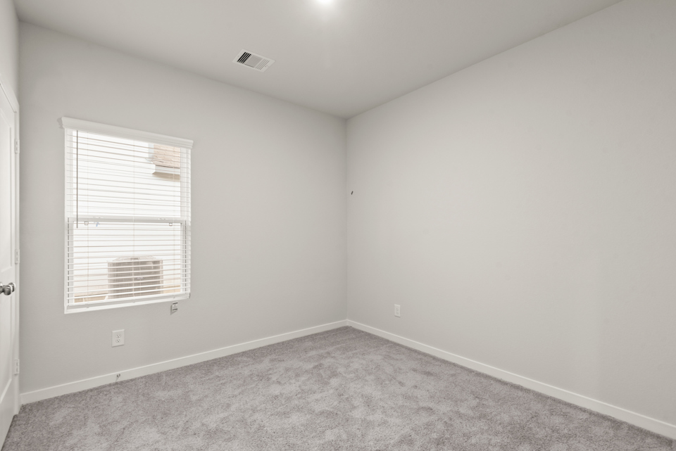 A room with a carpet and a window.