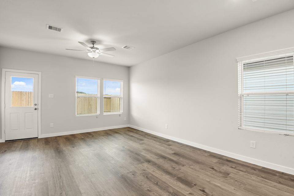 A room with a wood floor and a ceiling fan.