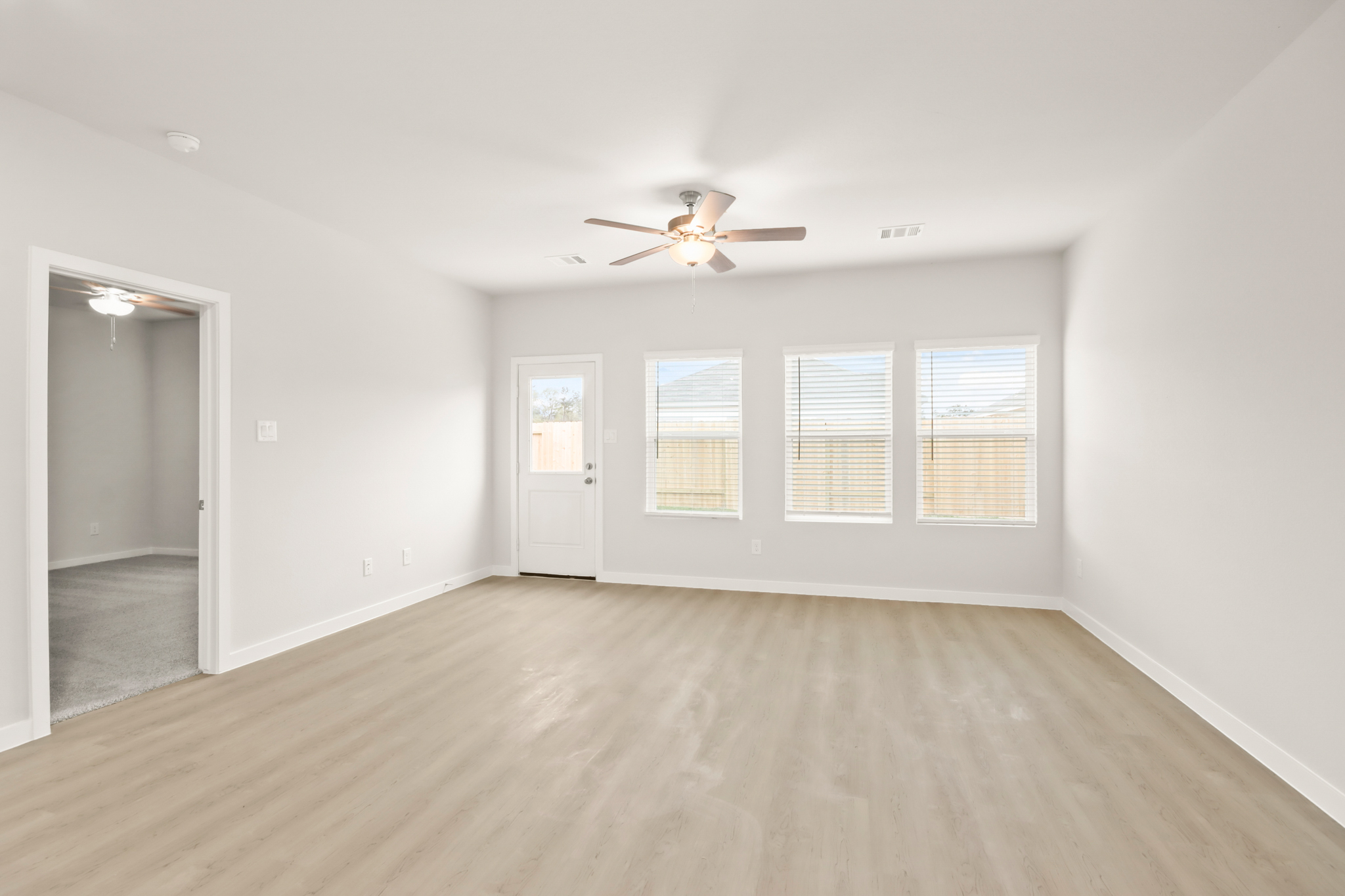 A room with a wood floor and a ceiling fan.