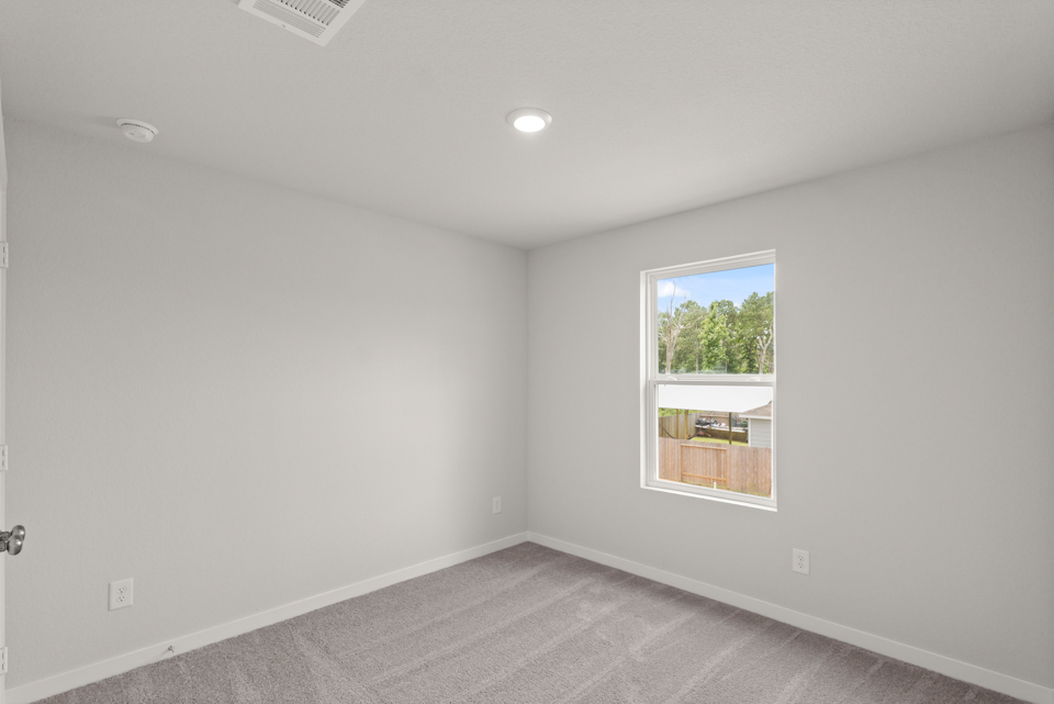 A room with a window and a carpet.