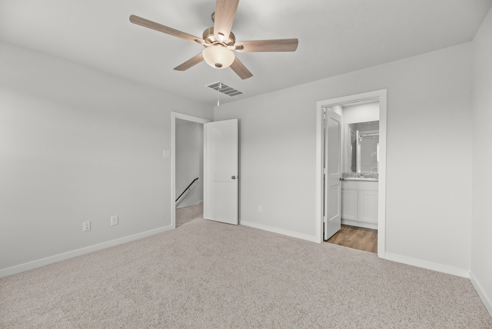 A room with a ceiling fan and a door.