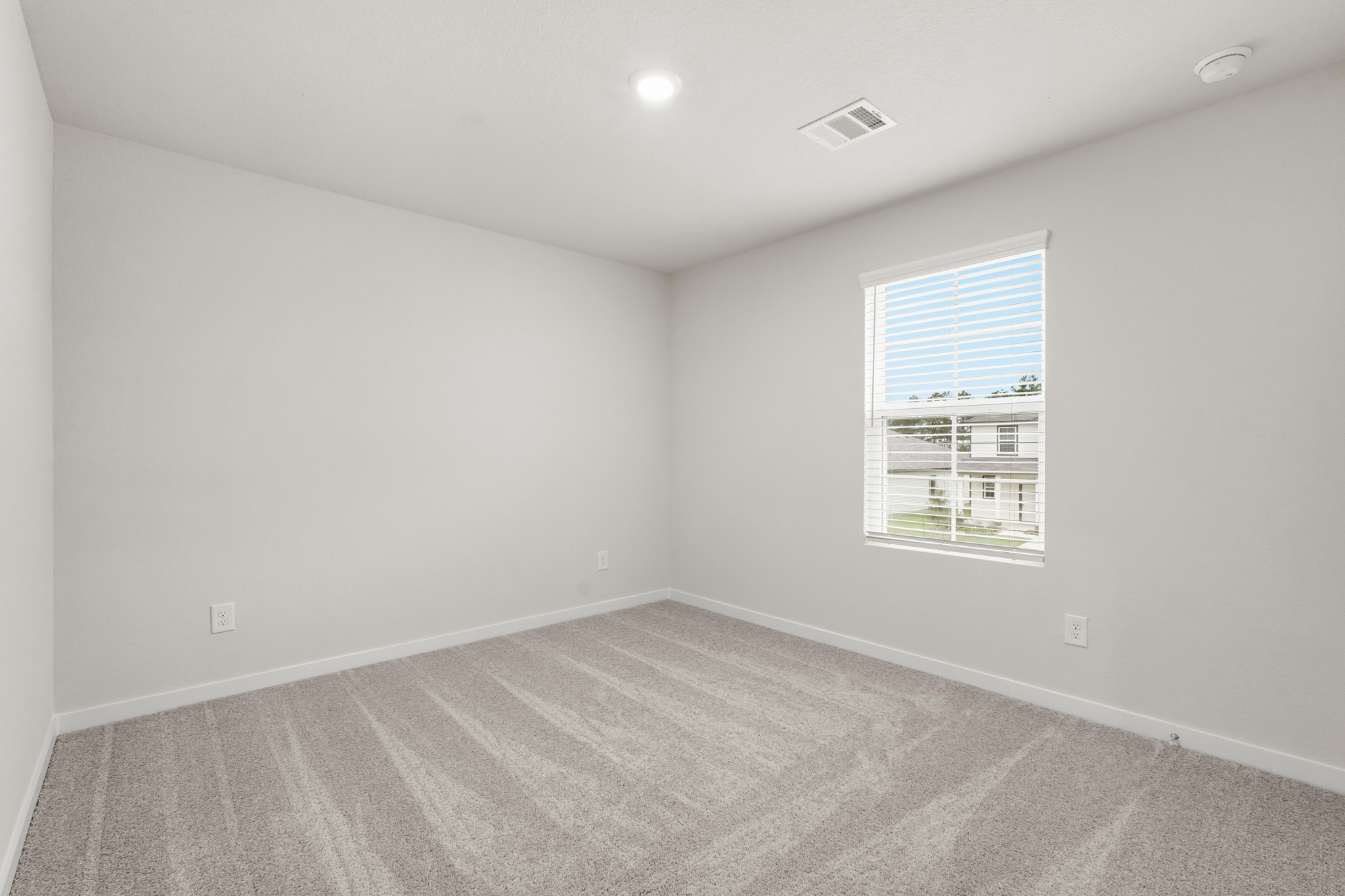 A room with a window and a carpet.