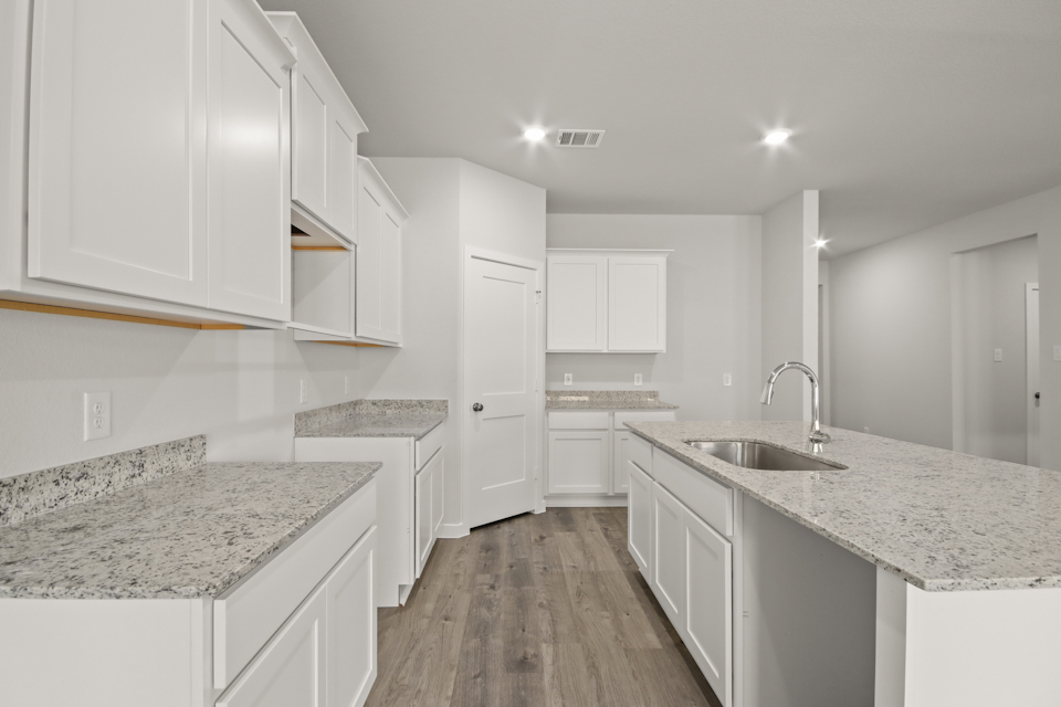 A kitchen with white cabinets.