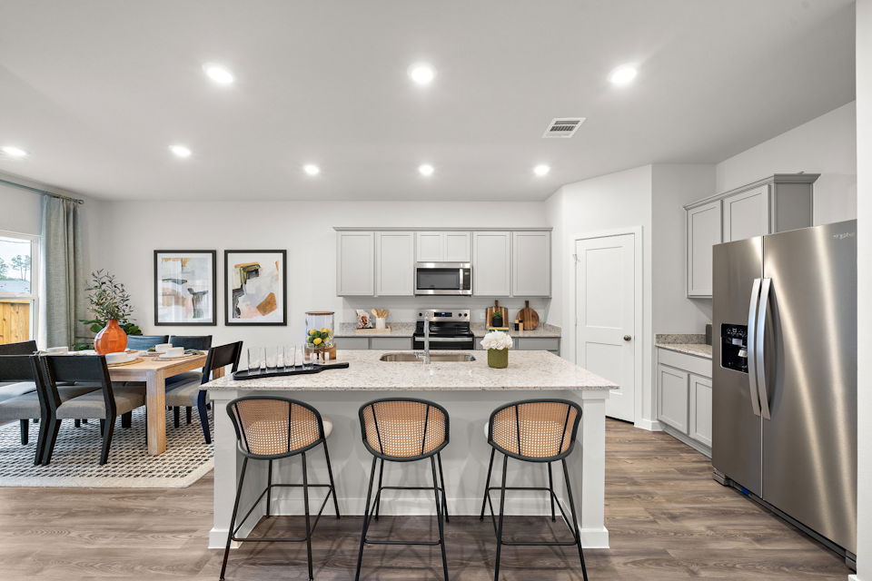 A kitchen with a table and chairs.