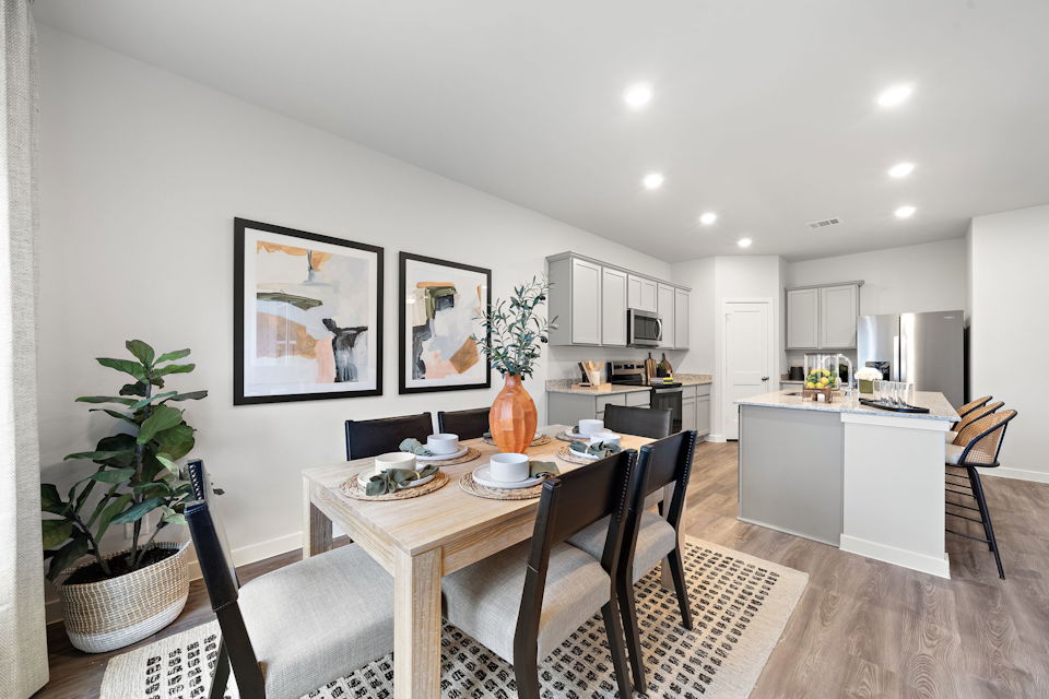 A kitchen with a dining table and chairs.