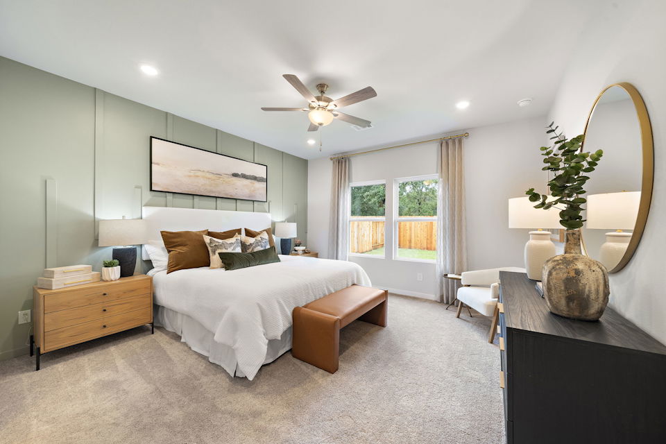 A bedroom with a large bed and a large mirror.