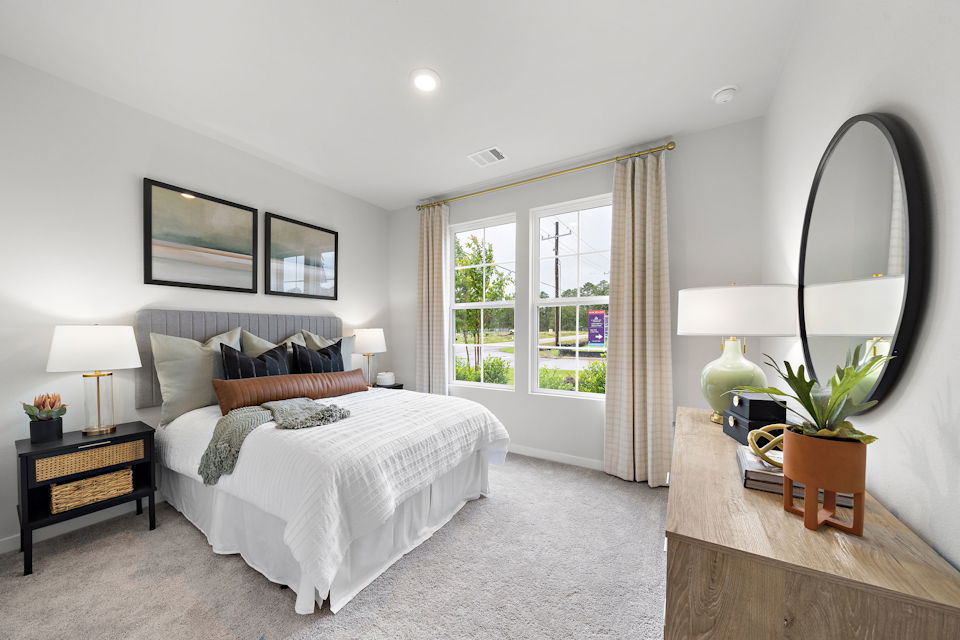 A bedroom with a large mirror.