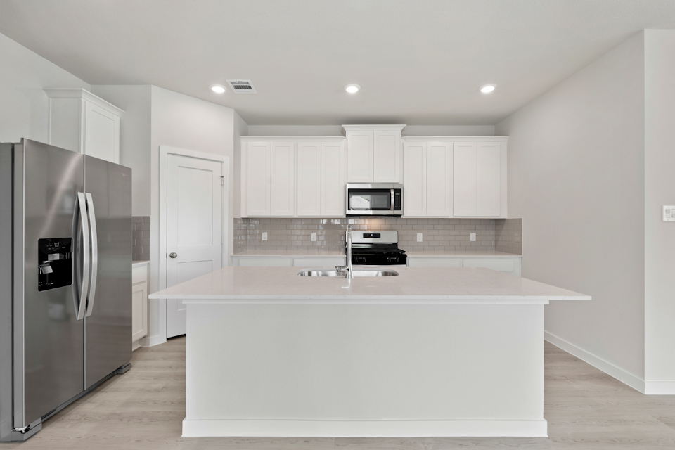 A kitchen with white cabinets.