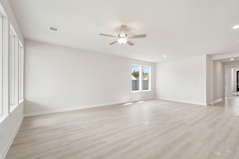 A room with a wood floor and a ceiling fan.