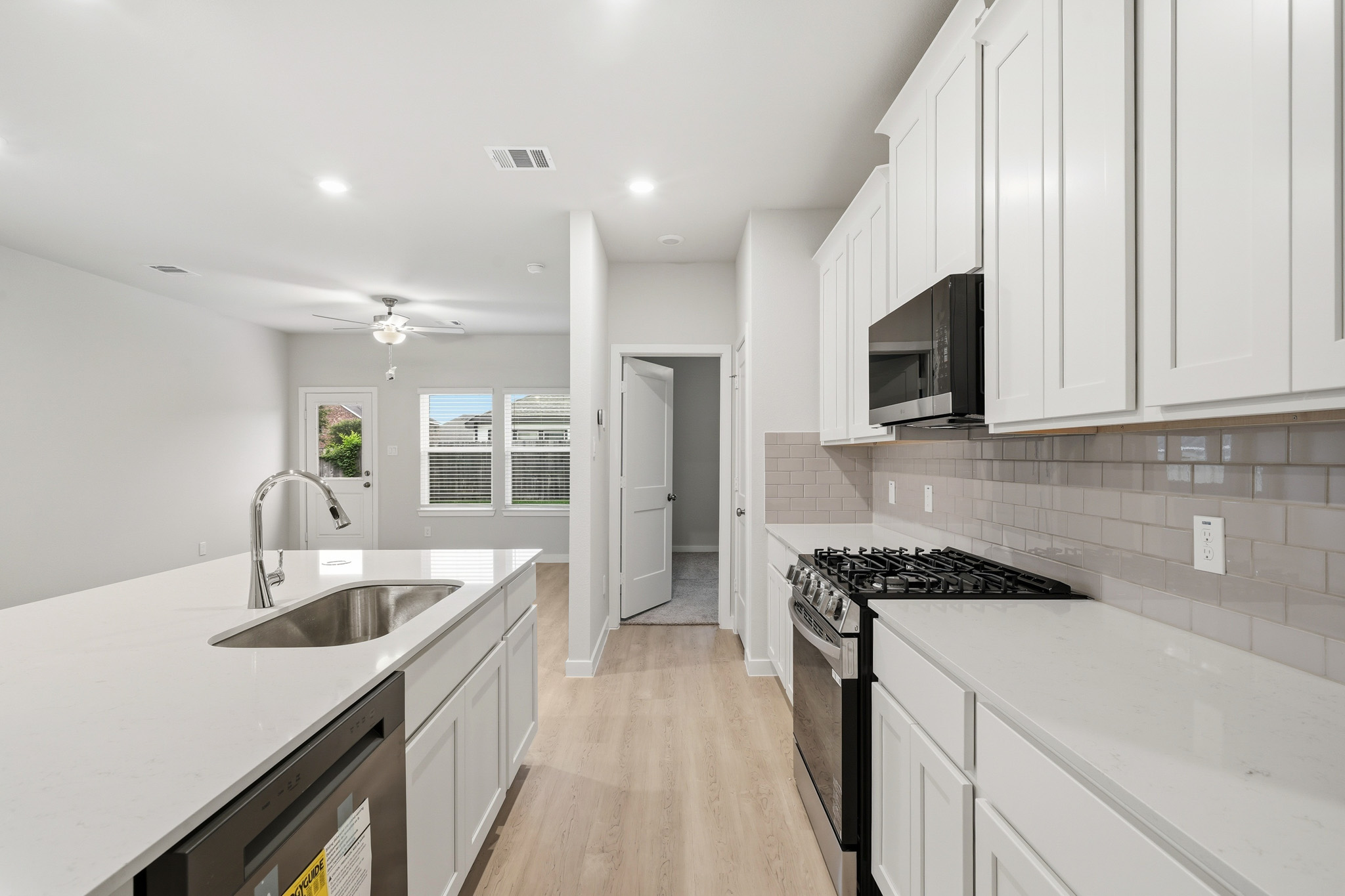 A kitchen with white cabinets.
