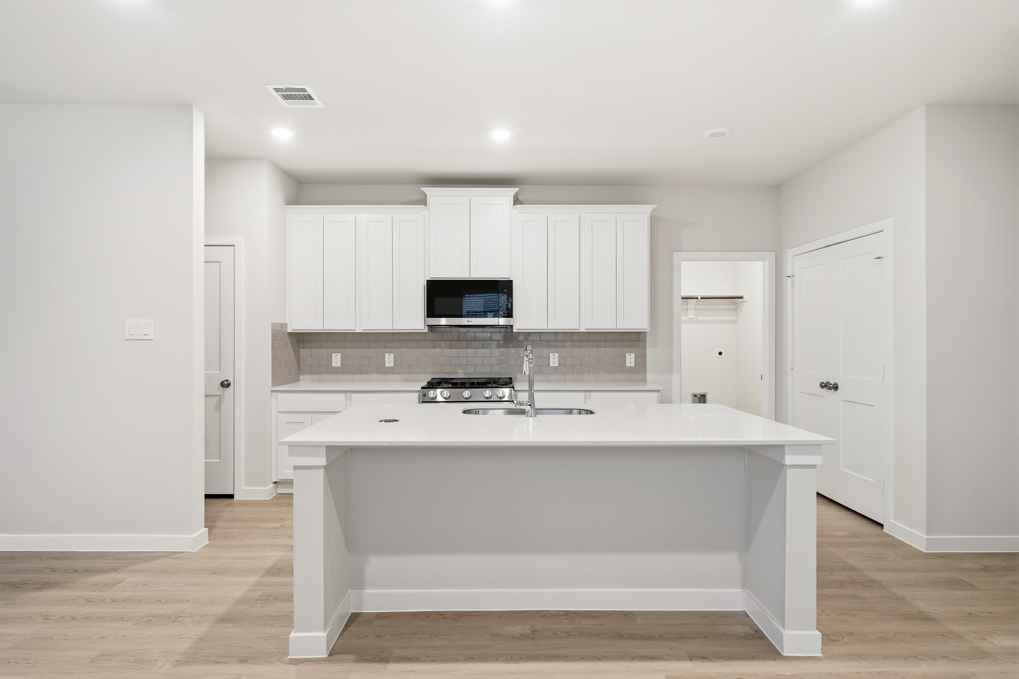 A kitchen with white cabinets.