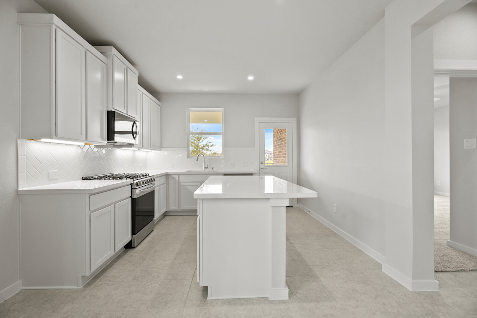 A kitchen with white cabinets.