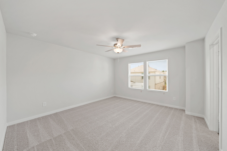 A room with a ceiling fan and a window.