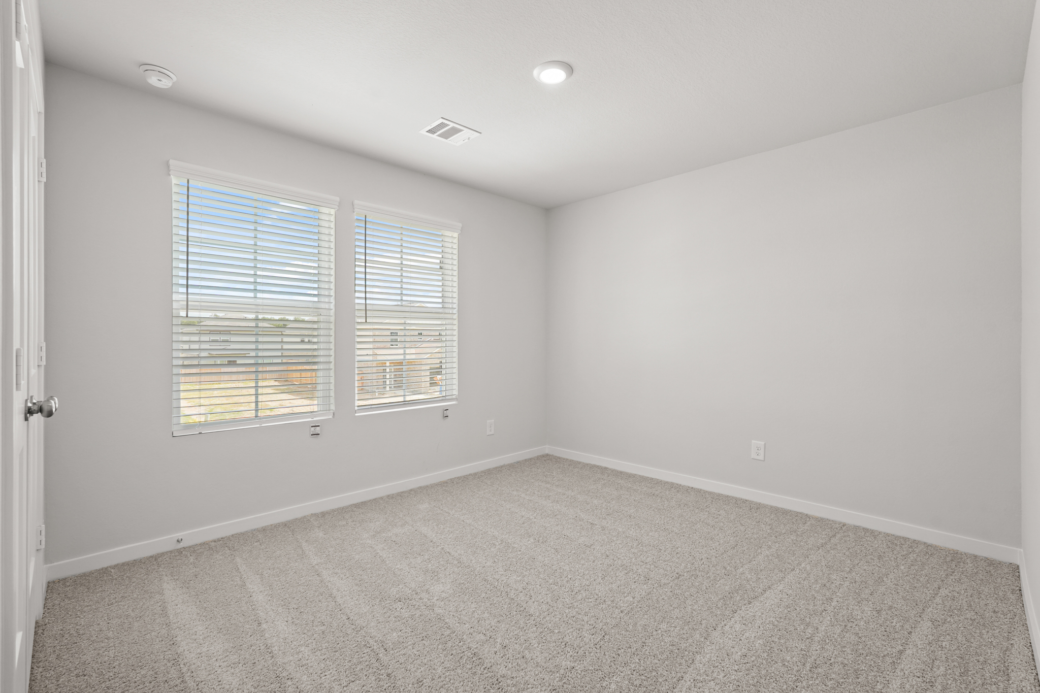 A room with a window and a carpet.