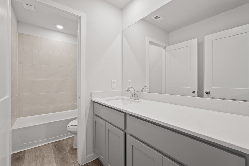 A bathroom with a tub sink and toilet.