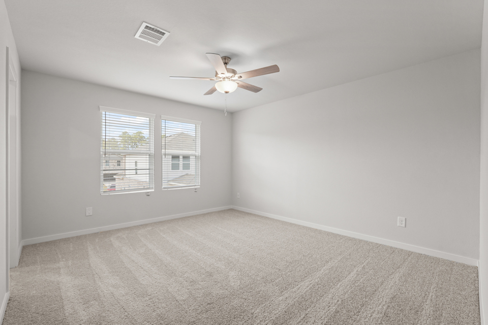 A room with a ceiling fan and a window.