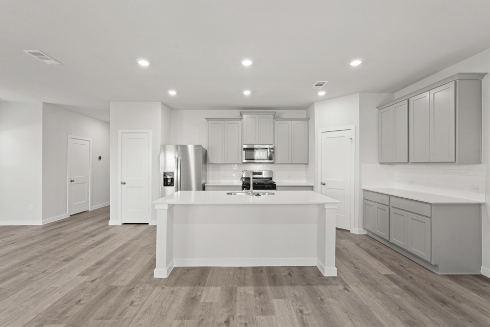 A kitchen with white cabinets.
