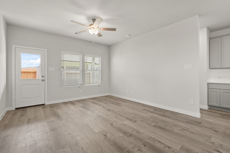 A room with a wood floor and a ceiling fan.