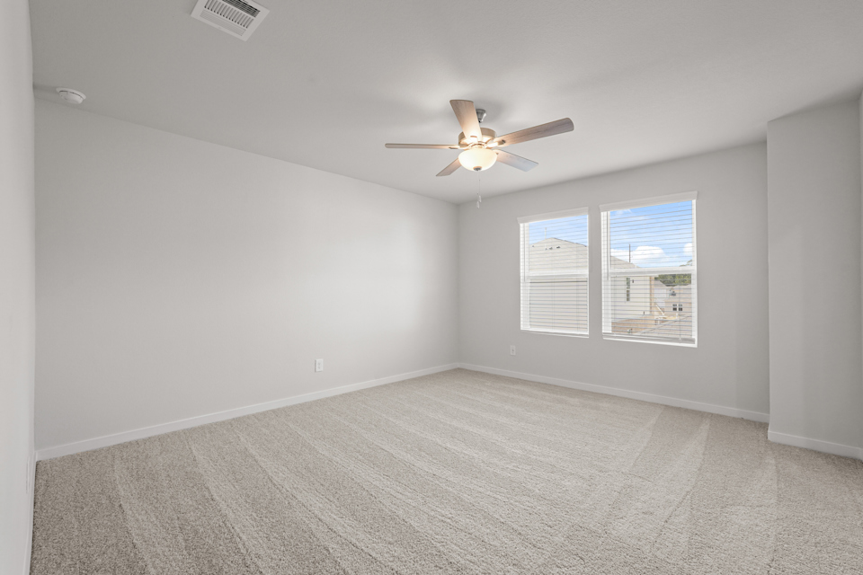A room with a ceiling fan and a window.