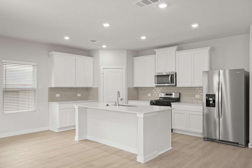 A kitchen with white cabinets.