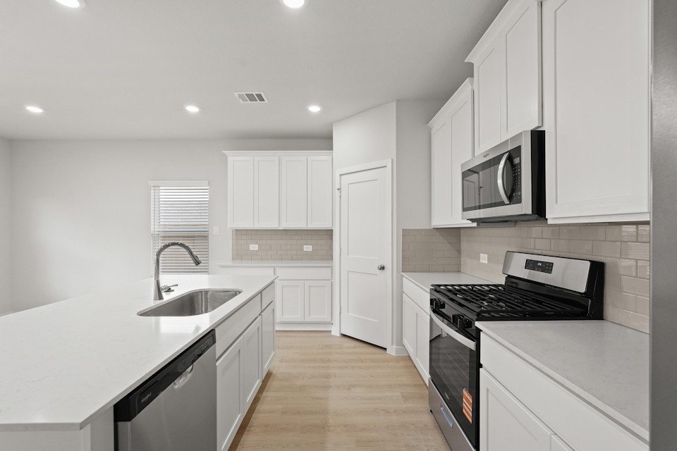 A kitchen with white cabinets.
