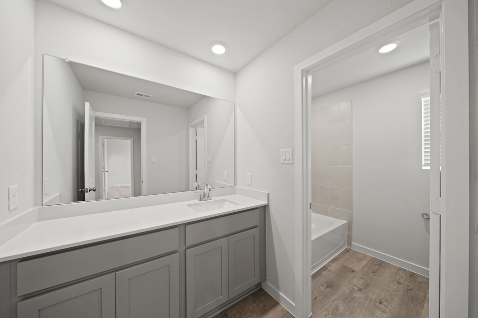 A bathroom with a tub sink and a shower.