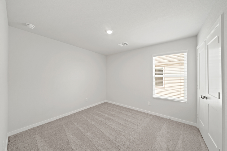 A room with a carpet and a door.