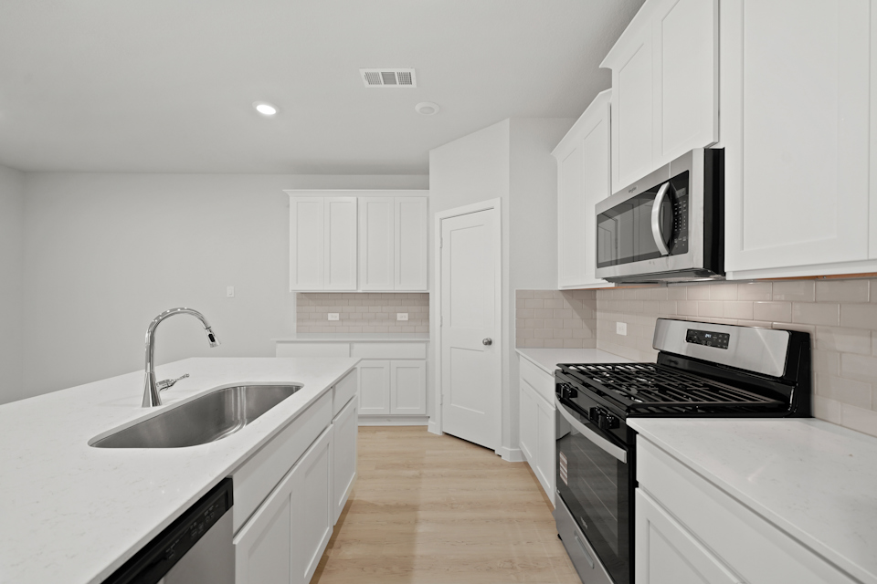 A kitchen with white cabinets.