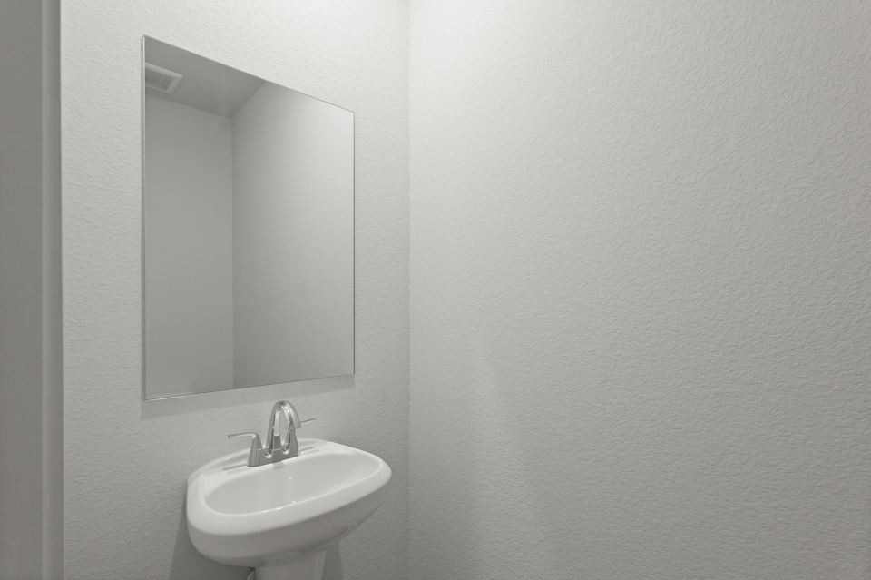 A bathroom with a round mirror.