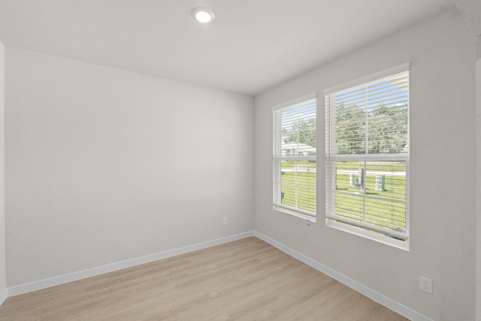 A room with a wood floor and windows.
