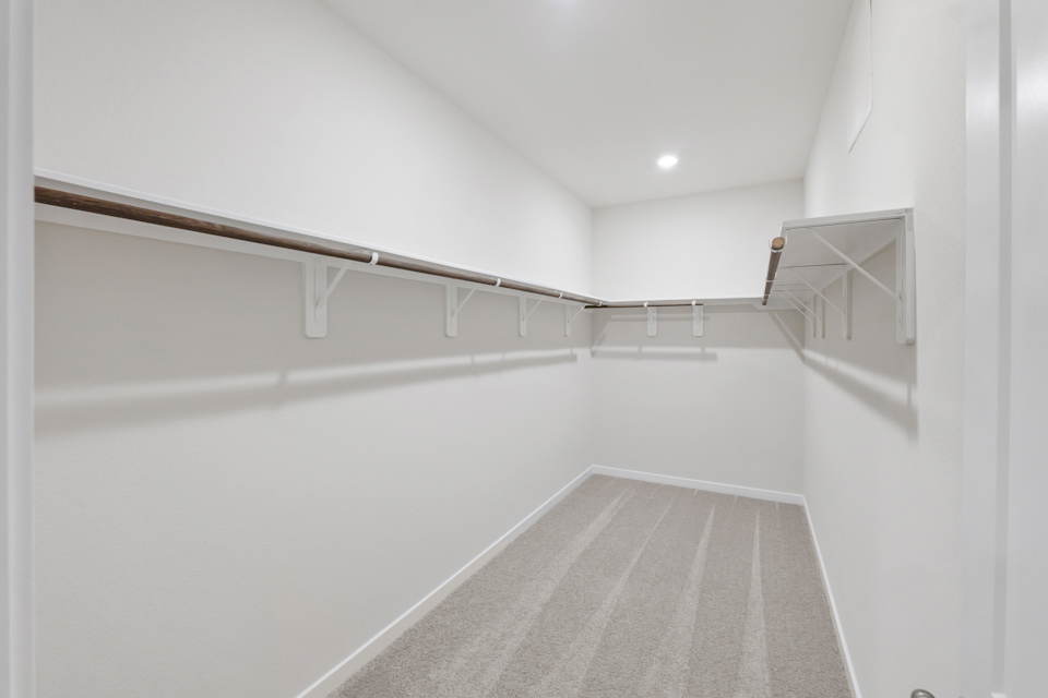 A white hallway with a metal railing.