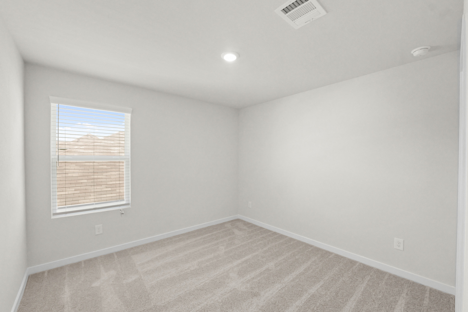 A room with a window and a rug.