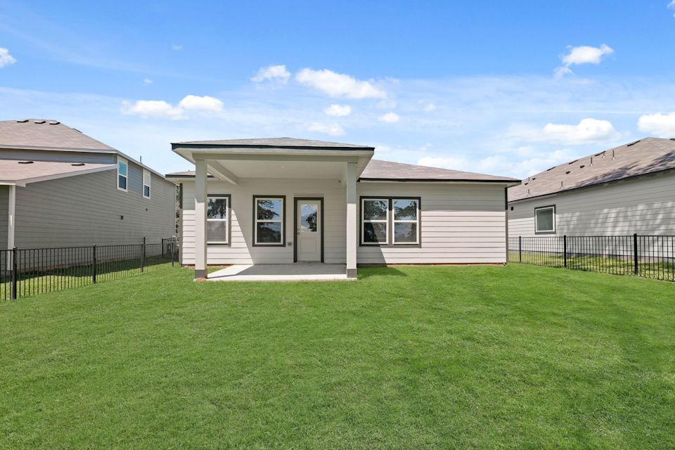 A house with a fence and grass.