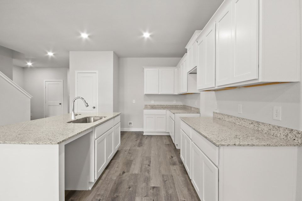 A kitchen with white cabinets.