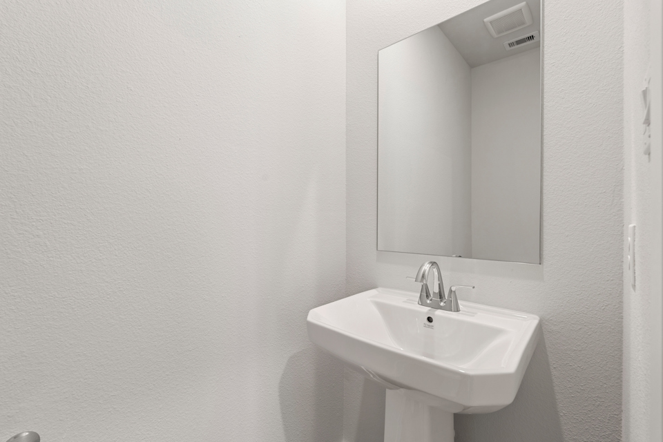 A bathroom with a mirror and sink.