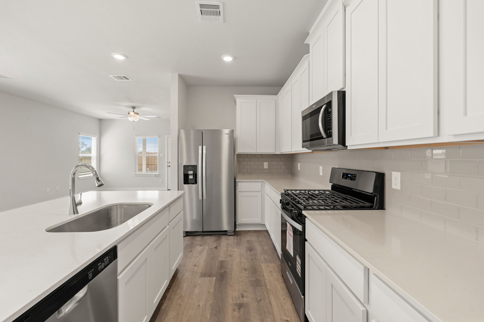 A kitchen with white cabinets.