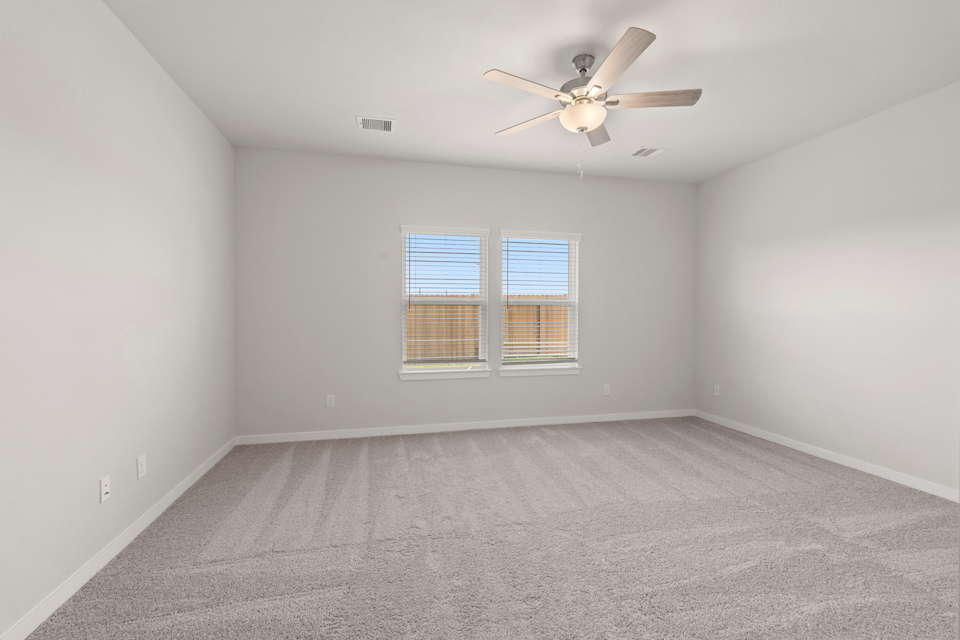 A room with a ceiling fan and a window.