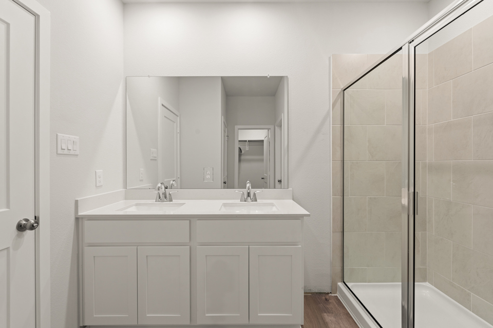 A bathroom with a sink and a shower unit.