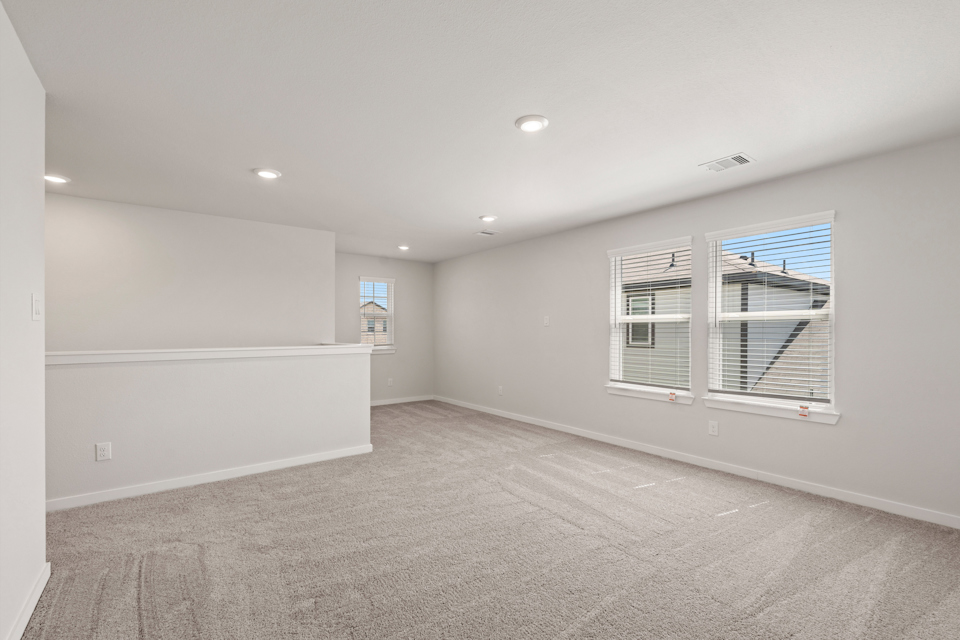 A room with a window and a white wall.