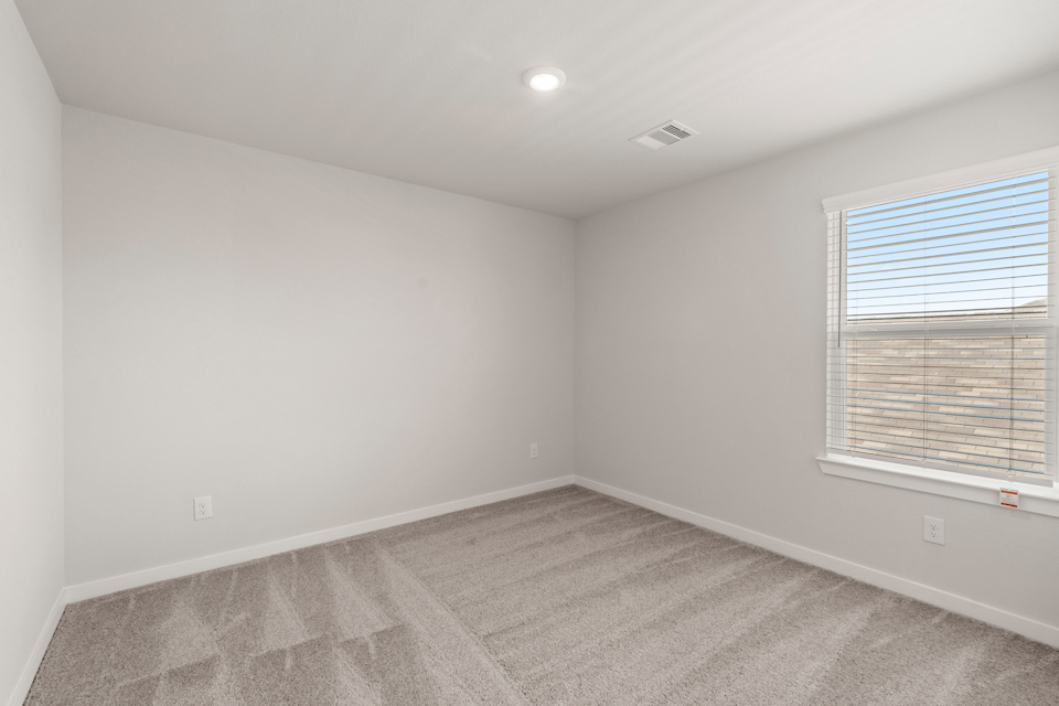 A room with a window and a carpet.