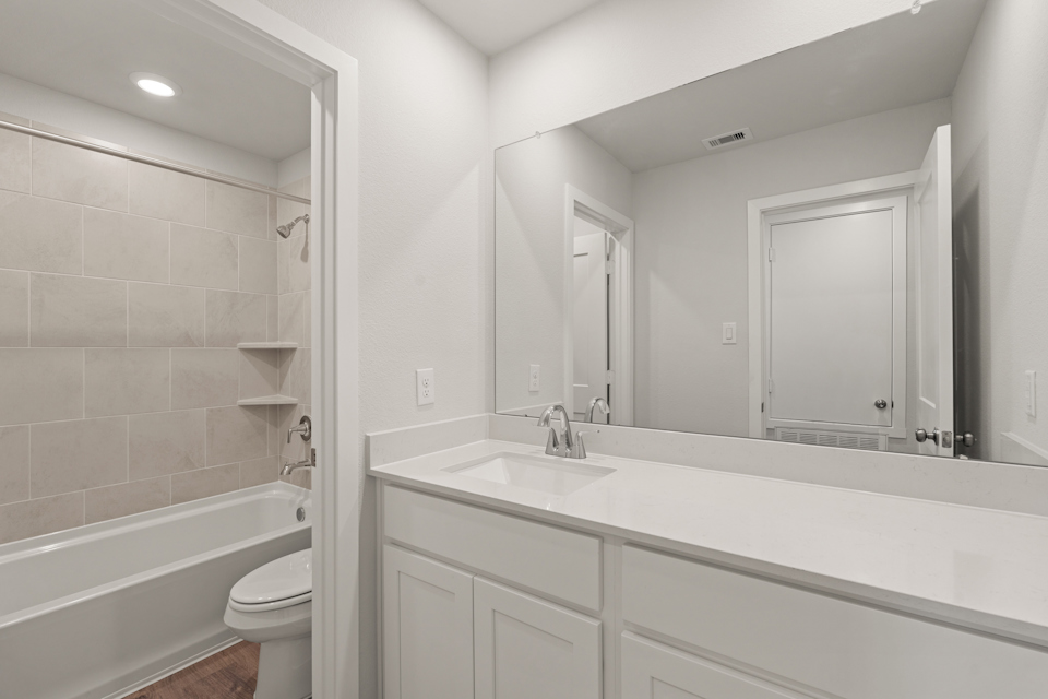 A bathroom with a tub sink and toilet.
