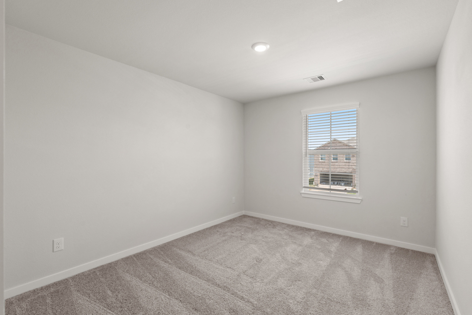 A room with a window and a carpet.