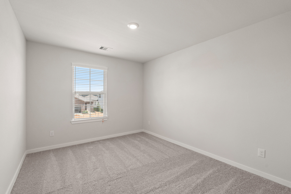 A room with a window and a carpet.