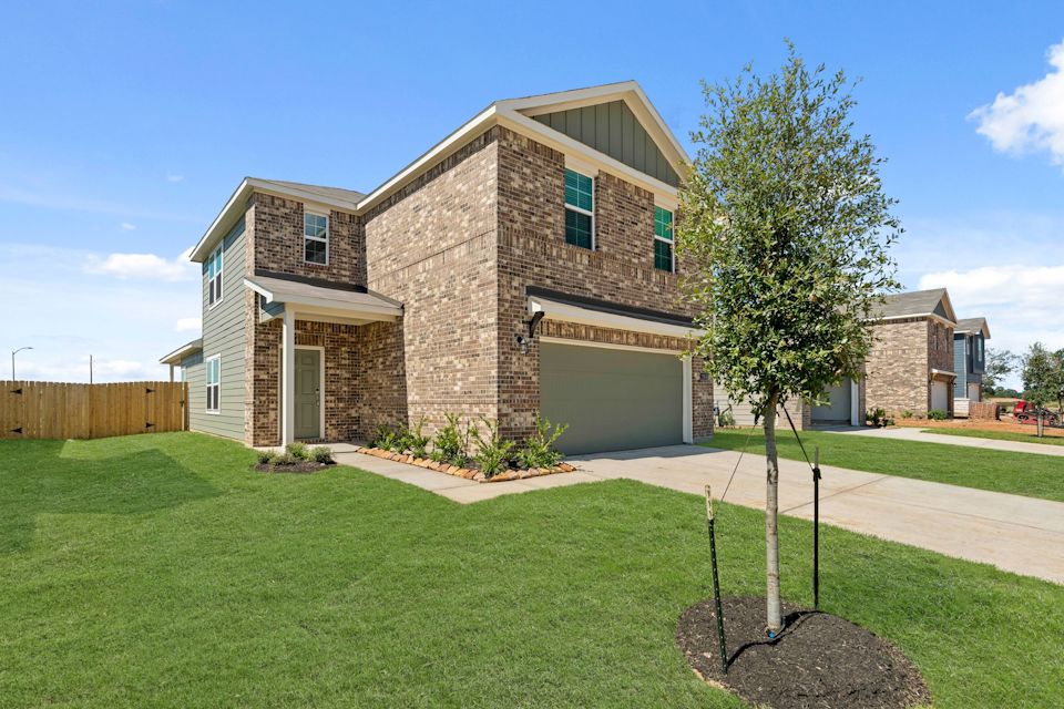 A large brick house with a tree in front of it.