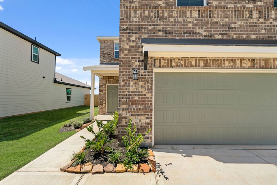 A building with a garage and grass.