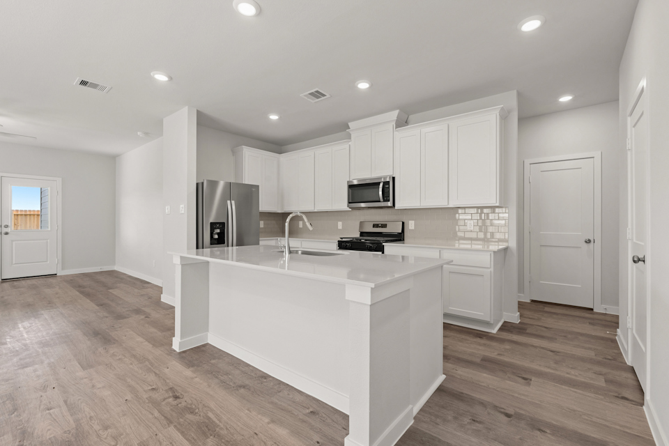 A kitchen with white cabinets.