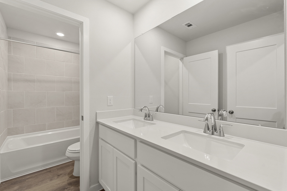 A bathroom with a tub sink and toilet.